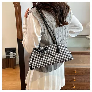Close-up detail of a black and white gingham Boston shoulder bag with a bow and heart charm