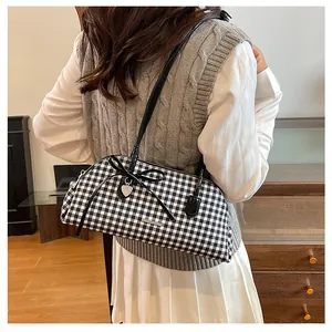 Close-up of a retro black and white gingham plaid Boston bag with bow and heart charm