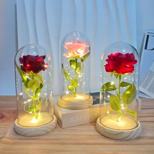 Artificial roses in glass domes with LED fairy lights on a wooden base in three colors.