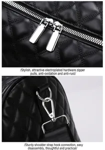 Detail shot of silver double zipper pulls and metal strap hook on black quilted bag