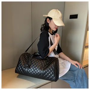 Detailed view of the black quilted travel duffle bag with adjustable shoulder strap
