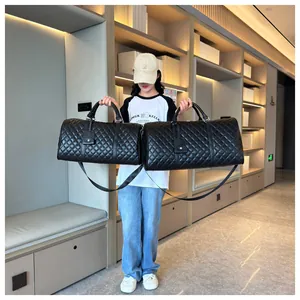 Comparison of two sizes of black quilted leather travel bags held by a stylish model