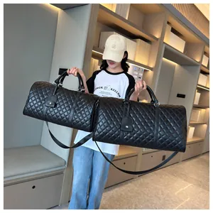 Detail showing two sizes of black quilted rhombic pattern travel duffel bags