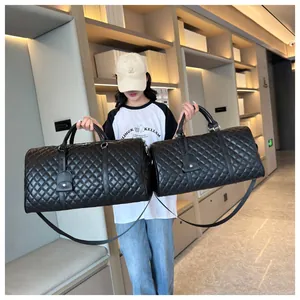 Stylish black quilted leather duffel bag for travel with adjustable shoulder strap detail.
