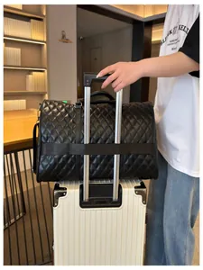 Close-up of black quilted duffel bag with a sleeve fitting over a suitcase handle.