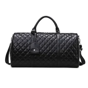 Elegant black quilted travel duffle bag with diamond pattern and adjustable strap.