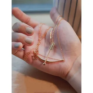 Elegant rose gold bow and arrow pendant necklace featuring a dainty adjustable chain