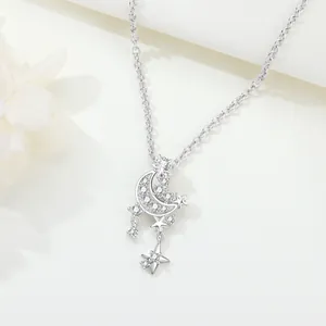 Close-up detail of silver star and moon pendant necklace with sparkling cubic zirconia stones.