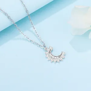 Close-up of elegant silver crescent moon pendant necklace with sparkling cubic zirconia.