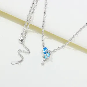 Detailed close-up of a silver-toned necklace featuring blue star and moon pendants