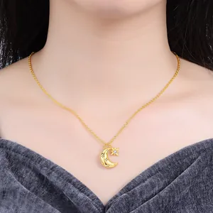 Close-up of a gold-colored necklace with star and moon pendant worn by a model