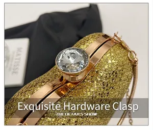 Detailed close-up showing the elegant rhinestone clasp of a golden glitter evening clutch bag