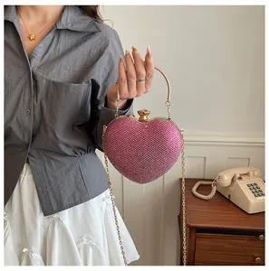 Close-up of sparkly fuchsia heart-shaped evening bag with gold chain strap