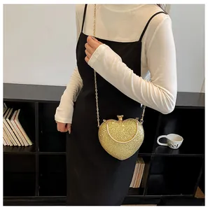 Detail of a sparkling heart-shaped golden evening bag with a elegant metal chain strap