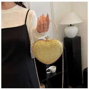 Close-up of glittery gold heart-shaped evening bag with metallic chain handle.