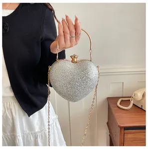 Close-up of elegant silver heart-shaped evening bag with gold chain strap