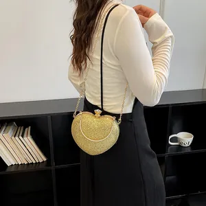 Sparkling heart-shaped gold glitter evening clutch bag with elegant gold chain strap for women