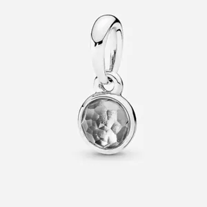 Detailed macro view of a silver-plated clear crystal birthstone charm for bracelets