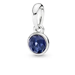 Macro view of blue birthstone charm with polished silver-plated finish detail