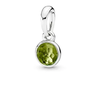 Detailed view of a silver-plated charm pendant with a faceted green birthstone.