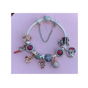 Silver plated charm bracelet featuring festive Christmas pendants on a pink backdrop