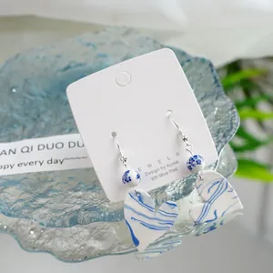 Close-up detail of blue and white porcelain heart earrings with 925 silver posts