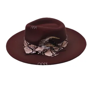 Elegant brown wide brim fedora cowboy hat with snakeskin band and feather decoration