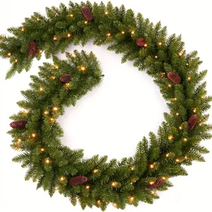 Artificial Christmas pine garland decorated with warm white LED lights and pinecones