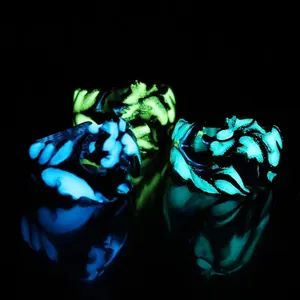 Luminous Chinese dragon pattern rings glowing in green and blue on black background