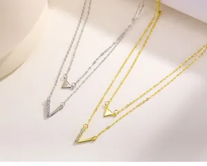 Close-up detail of double layered S925 silver necklaces with V-shape and triangle pendants