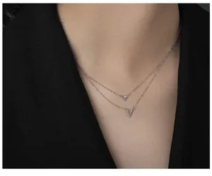 Close-up of S925 silver double-layered necklace with V and triangle pendants on neck