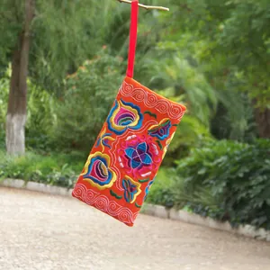 Detail of traditional ethnic floral embroidery on orange canvas long wallet pouch