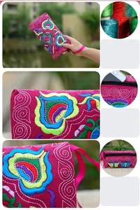 Detailed view of ethnic Miao embroidery on a vibrant pink floral canvas coin purse