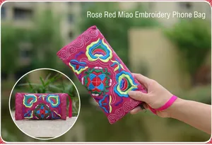 Detailed view of rose red Miao embroidered ethnic phone bag with vibrant floral patterns