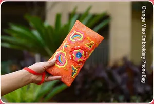 Detailed view of orange Miao ethnic style embroidered phone bag with floral patterns