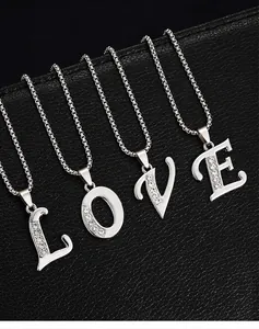 Détail de colliers en argent avec initiales serties de strass formant le mot LOVE.