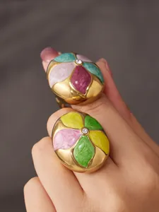 Exquisite close-up detail of colorful enamel flower rings with central zircon stone.