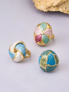 Detailed view of various colorful enamel and stainless steel floral rings set
