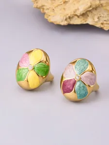 Detailed macro view showing colorful enamel flower petals with a center zircon on a gold ring