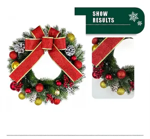 Détail d'une couronne de Noël avec un grand nœud rouge pailleté et des boules