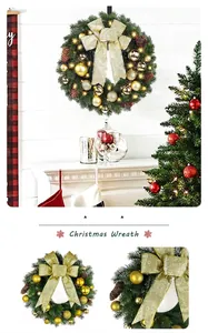 Couronne de Noël verte traditionnelle avec ruban doré et boules sur une cheminée