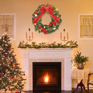 Couronne de Noël festive avec nœud rouge scintillant et lumières LED sur la cheminée