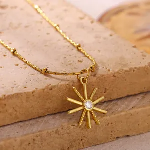 Detailed view of 18K gold-plated necklace featuring a radiant sun starburst pendant.