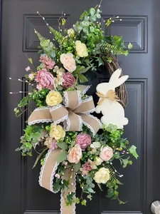 Artificial Easter flower wreath featuring a bunny silhouette and large burlap bow decoration