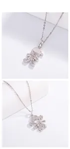 Close-up detail of silver-colored cartoon boy and girl pendant necklaces