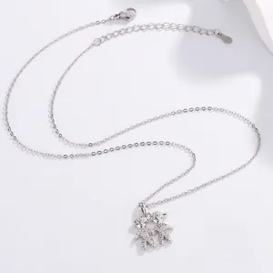 Detailed macro shot of a cute titanium steel cartoon children character pendant necklace.