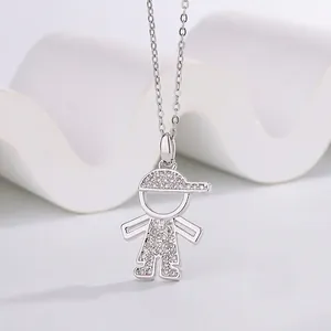 Detailed macro view of a cute cartoon boy pendant necklace with sparkling stone accents.