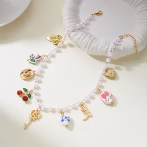 Detailed view of pearl choker with various gold charms like cherry, bow, and key