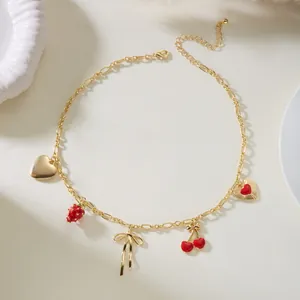 Detailed view of sweet gold chain necklace with cherry, strawberry and heart pendants.