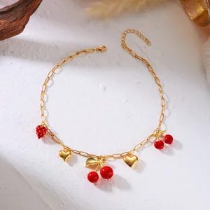 Gold-tone necklace detail featuring sweet cherry, strawberry and heart pendant charms.